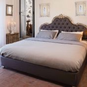 Двуспальная кровать с мягким изголовьем и стильные детали для спальни