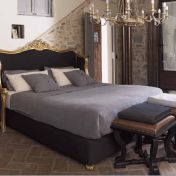 Классическая спальня с большой кроватью в текстильной обивке